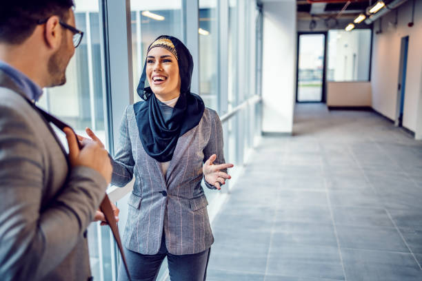 Two business professionals discussing within a modern office space, highlighting real estate management in Dubai.