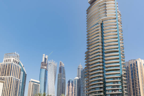 Modern high-rise buildings in the Al Rashidiya area of Dubai under a clear blue sky.